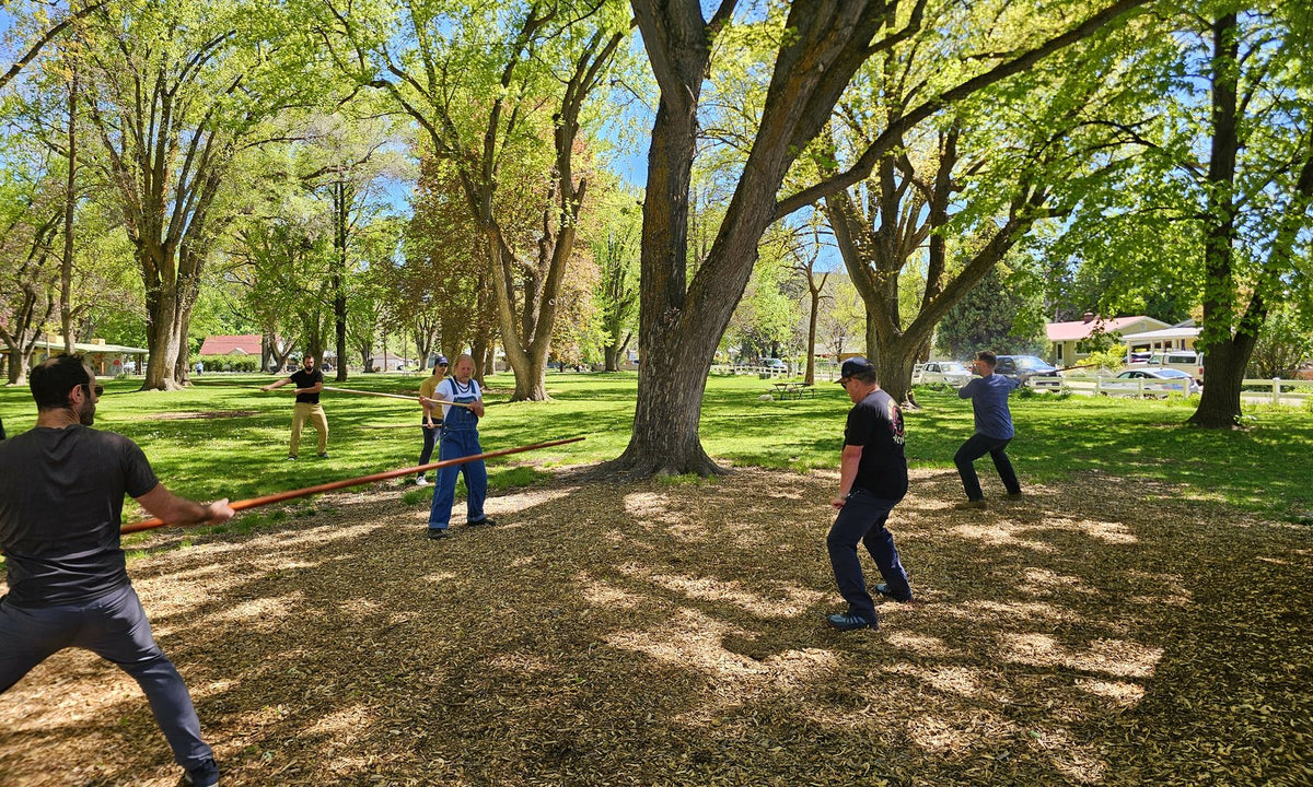 A group class practising outdoors under the trees